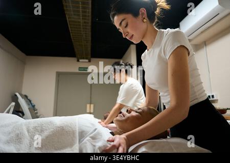 Femme se relaxant pendant un massage professionnel du cou dans le spa Banque D'Images