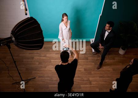 Personnes travaillant sur une séance photo de mode studio Banque D'Images