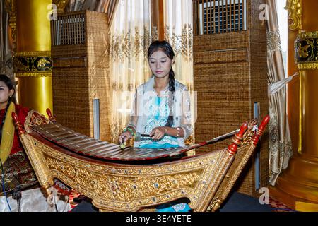 Une jeune et jolie femme locale joue un pattala, un xylophone birman traditionnel dans le restaurant de Karaweik Barge, Yangon (Rangoon), Myanmar (Birmanie) Banque D'Images