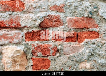 Vieux mur de briques avec texture rugueuse et ciment. Fond de surface altérée, texture. Banque D'Images