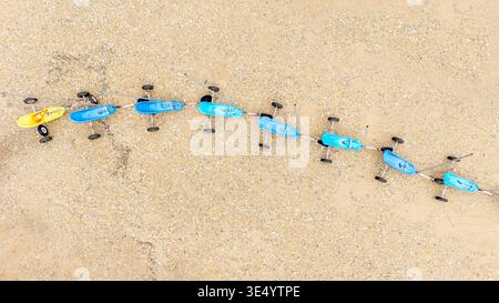 Vue aérienne d'une ligne de voitures jouets colorées s'étendant sur le sol sablonneux, Fort-Mahon-plage, hauts-de-France, France. Banque D'Images