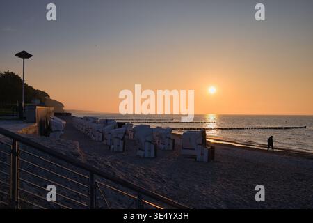 Weiße Strandkörbe am Strand von Heiligendamm BEI Sonnenuntergang mit einem Spaziergänger am Ufer der Ostsee in Mecklenburg-Poméranie occidentale Banque D'Images