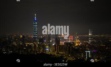 Vue aérienne du gratte-ciel de Taipei 101 et de la ville illuminée la nuit avec des lumières urbaines incandescentes sous un ciel sombre dans le village de Xicun, Taipei CIT Banque D'Images