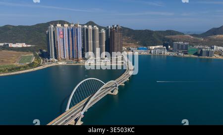 Vue aérienne du pont Cross Bay Link avec son arc distinctif et ses gratte-ciel résidentiels modernes le long du front de mer dans les nouveaux Territoires, Hong Ko Banque D'Images