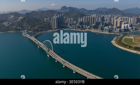 Vue aérienne du pont Cross Bay Link avec son arc emblématique qui traverse les eaux bleues de Junk Bay vers la gratte-ciel et le mou vert luxuriant Banque D'Images