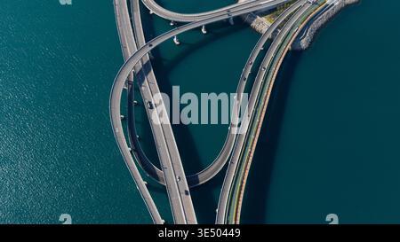 Vue aérienne de l'échangeur du pont Cross Bay Link avec des routes courbes au-dessus de l'eau bleue profonde dans les nouveaux Territoires, Hong Kong. Banque D'Images