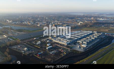Vue aérienne du centre de données de Winschoten avec de grands panneaux solaires et une infrastructure industrielle entourée de champs et de la ville Banque D'Images