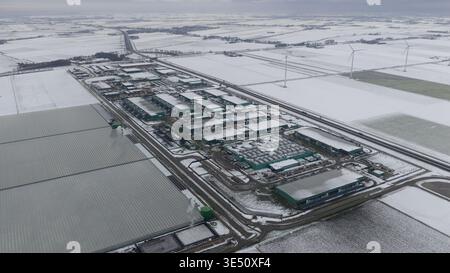 Vue aérienne du centre de données Agriport a7 entouré de champs enneigés, d’éoliennes et de grandes serres à Middenmeer, Noord-Holland Banque D'Images