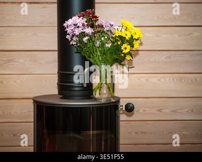 un bouquet en vase avec de l'eau placé sur le dessus de la cheminée, tir intérieur Banque D'Images