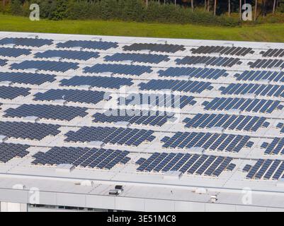 La vue aérienne montre des panneaux solaires installés sur un grand toit. Ces panneaux soutiennent la production d’énergie propre et contribuent à la durabilité. Banque D'Images