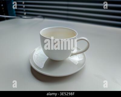 Tasse à café sale et soucoupe sur le bureau, restes de taches de café, encombrement sur le lieu de travail, vie de bureau quotidienne et gros plan sur une scène de bureau décontractée Banque D'Images