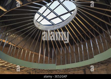 Un intérieur de bâtiment moderne avec une ossature métallique et un puits de lumière ovale saisissant, capturant la conception architecturale en cours Banque D'Images
