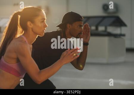 Couple de fitness se préparant à courir au coucher du soleil sur le toit Banque D'Images