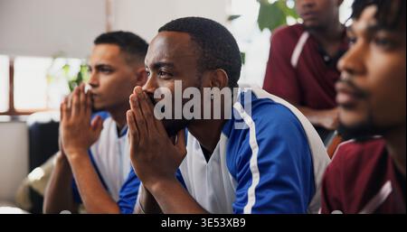 Fans, regarder la télévision et s'inquiéter avec des amis sur le canapé dans le salon de la maison pour la compétition ou le soutien. Streaming, stress et télévision avec groupe d'hommes dans Banque D'Images