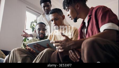 Frustré, hommes et tablette en interne avec match de sport, perte de match de football et divertissement en ligne. Angle bas, amis et diffusion en direct dans le salon Banque D'Images