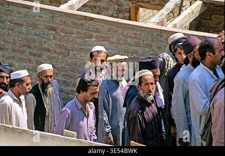 Des groupes d'hommes marchent ensemble à Peshawar. Ils se dirigent vers leur emploi tôt dans la journée. La scène montre la vie quotidienne dans la ville. Banque D'Images