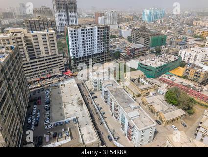 Vue aérienne des immeubles d'appartements modernes et des chantiers de construction avec des rues animées de la ville et des voitures garées à Karachi, Sindh, Pakistan. Banque D'Images