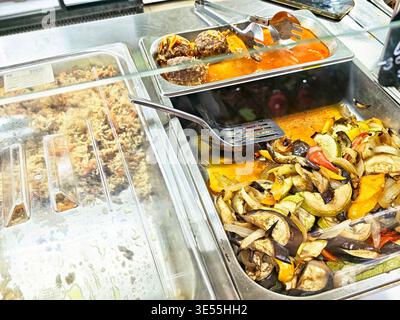 Orenburg, Russie - 22 août 2025 : les visiteurs peuvent voir des légumes cuits colorés et des boulettes de viande servis dans des plateaux dans une station-service de restauration très fréquentée pendant le lu Banque D'Images