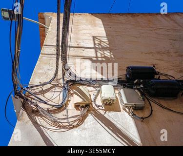 Câbles électriques et Internet désordonnés sur le mur du bâtiment Banque D'Images