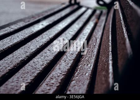 Texture de banc en bois imbibée de pluie dans City Park Banque D'Images