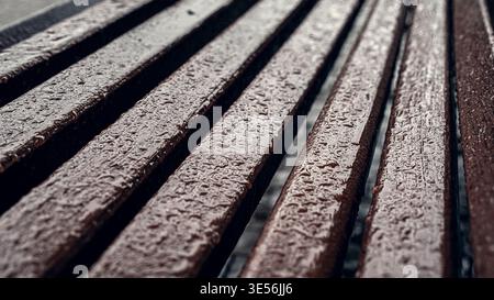 Texture de banc en bois imbibée de pluie dans City Park Banque D'Images