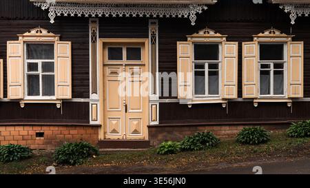 Façade de maison traditionnelle en bois avec fenêtres et porte ornées Banque D'Images