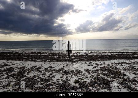Jeune femme debout sur la plage de Bofa, Kilifi, Kenya Banque D'Images