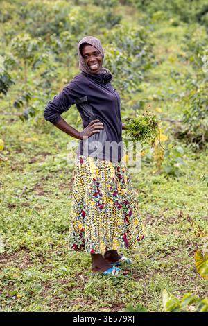 Femme souriante debout dans un jardin à l'ouest du Rwanda Banque D'Images