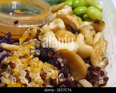 Gros plan macro-photo d'un récipient de préparation de repas sain avec un assortiment coloré d'ingrédients nutritifs. Le plat contient du quinoa mélangé Banque D'Images