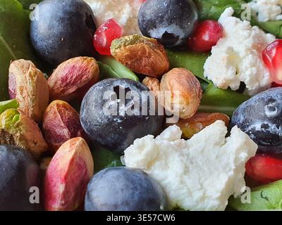 Macro-photographie en gros plan d'une composition de salade colorée et saine mettant en vedette des bleuets frais avec leurs indentations de couronne caractéristiques, Banque D'Images