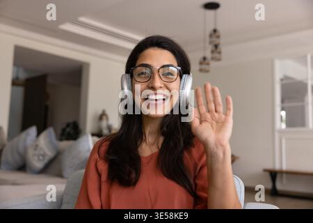 Femme souriante agitant pendant un appel vidéo en ligne Banque D'Images
