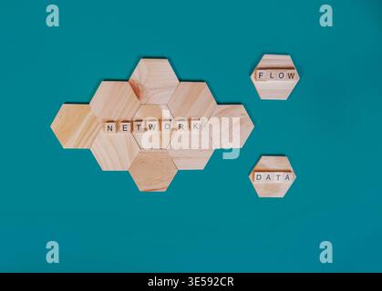 Carreaux de lettres en bois formant les mots Network, flow et data sur des blocs hexagonaux, symbolisant l'échange d'informations et la connectivité numérique à travers un Banque D'Images