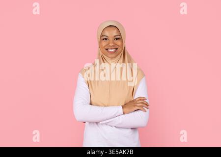 Jeune femme musulmane noire confiante en hijab beige debout avec les bras croisés Banque D'Images