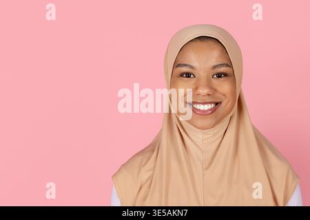 Gros plan portrait d'une jeune femme musulmane noire en hijab beige souriant naturellement Banque D'Images