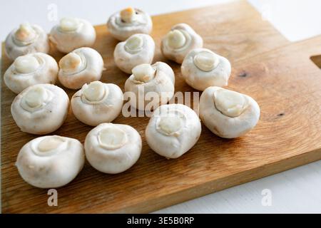 Champignons frais (champignons blancs) sur planche à découper en bois Banque D'Images
