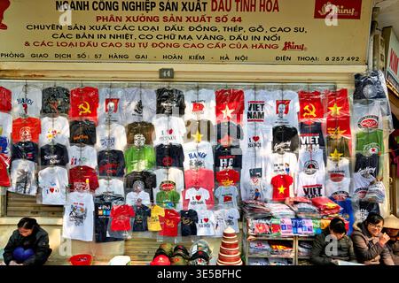 Stall affiche de nombreux T-shirts colorés à vendre à Hanoi, Vietnam. Les fournisseurs locaux présentent différentes conceptions pour les clients. Banque D'Images