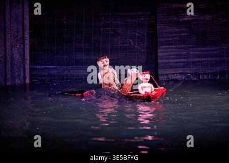 Des marionnettes d'eau se produisent sur une petite scène à Hanoi. Le cadre propose de la musique traditionnelle et des contes, mettant en valeur la culture vietnamienne. Banque D'Images