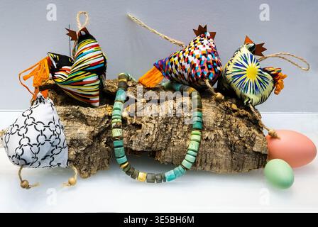 Décorations de poulet de Pâques en tissu fait à la main avec collier de perles sur écorce Banque D'Images