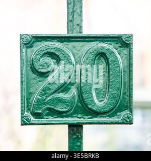 Gros plan de la maison en métal vert numéro 20 sur la porte, concept d'adresse, d'identification et de navigation Banque D'Images