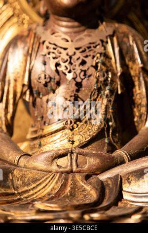 Gros plan d'une statue de Bouddha dorée montrant des mains détaillées dans le mudra de méditation, symbolisant la paix, la spiritualité et l'illumination avec ornam complexe Banque D'Images
