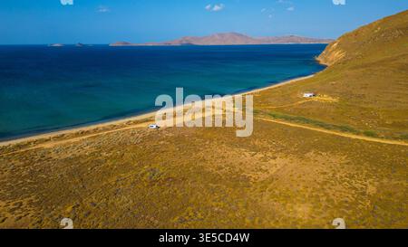 Vue aérienne par drone d'un camping-car garé à la plage Parthenomitos sur l'île de Limnos, Grèce. Paysage côtier méditerranéen isolé avec mer turquoise Banque D'Images
