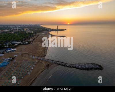 Cavallino Italie - 5 septembre 2025 : vue aérienne d'un lever de soleil sur la plage avec la mer Égée sur une île près de Venise avec un phare Banque D'Images