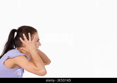 Femmes pressant les mains à la tête sur fond blanc dans le dessus de lavande avec cravate de cheveux, espace de copie. Portrait, stock, Highkey, studio, violet, queue de cheval, commerce Banque D'Images