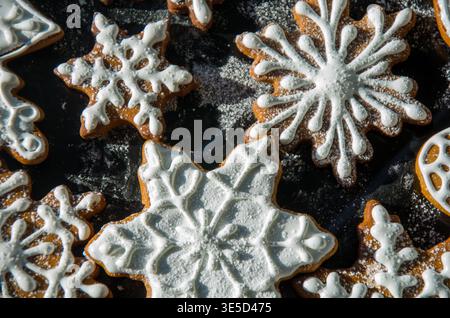 Biscuits au pain d'épices glacés à base de flocons de neige sur une surface sombre Banque D'Images