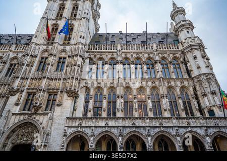Vue rapprochée et inclinée de la façade de l'hôtel de ville de Bruxelles. L'image met en évidence les sculptures gothiques complexes, les fenêtres pointues, et le belge et E. Banque D'Images
