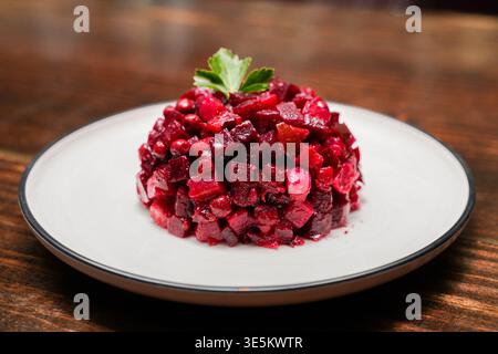 Salade venegret sur assiette blanche sur barre en bois Banque D'Images