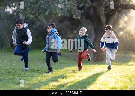 Enfants multiethniques courir, jouer ensemble dans le parc extérieur Banque D'Images