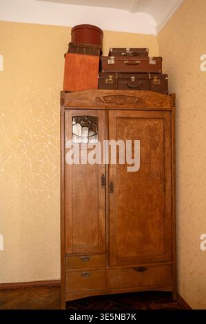 Ancienne armoire en bois avec valises vintage et boîtes à chapeau sur le dessus. Meubles en bois massif. Concept de voyage historique, solutions de stockage rétro, et ho Banque D'Images