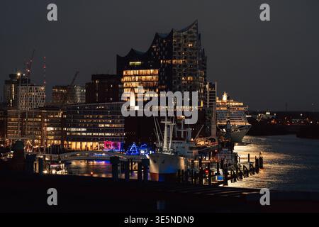 Deutschland, Hamburg : Elbphilharmonie BEI Nacht, beleuchtete Glasfassade, ikonische Architektur an der Elbe.Vordergrund : Überseebrücke mit Anlegern und Hafeninfrastruktur, Museumsschiff Cap San Diego. Hintergrund : P&O Iona Kreuzfahrtschiff im Fahrwasser, Hell beleuchtet, moderne Passagierschifffahrt. Weiter hinten : Baustelle Elbtower, politisch umstritten, Baustopp kurzer Olaf als Verweis auf die Debatte um Olaf Scholz. Kontrast : historische Schifffahrt, moderne Architektur und aktuelle Stadtentwicklung treffen aufeinander, ruhige, nächtliche Hafenstimmung. Hambourg *** Allemagne, Hambourg Elbphil Banque D'Images