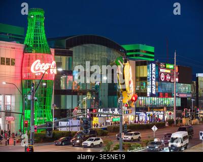 La nuit tombe sur le Strip de Las Vegas, où les lumières vives et la foule définissent l'énergie emblématique de la ville. Enseignes au néon et écrans publicitaires Banque D'Images